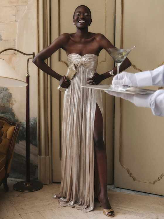 Elegantes, bodenlanges Abendkleid in Champagnerton mit trägerlosem Oberteil, Drapierungen und hohem Beinschlitz. Fließend, feminin und ausdrucksstark.