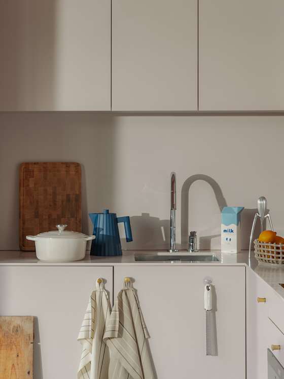 Moderne Küche mit hellen Fronten, Spüle und Holzdetails.