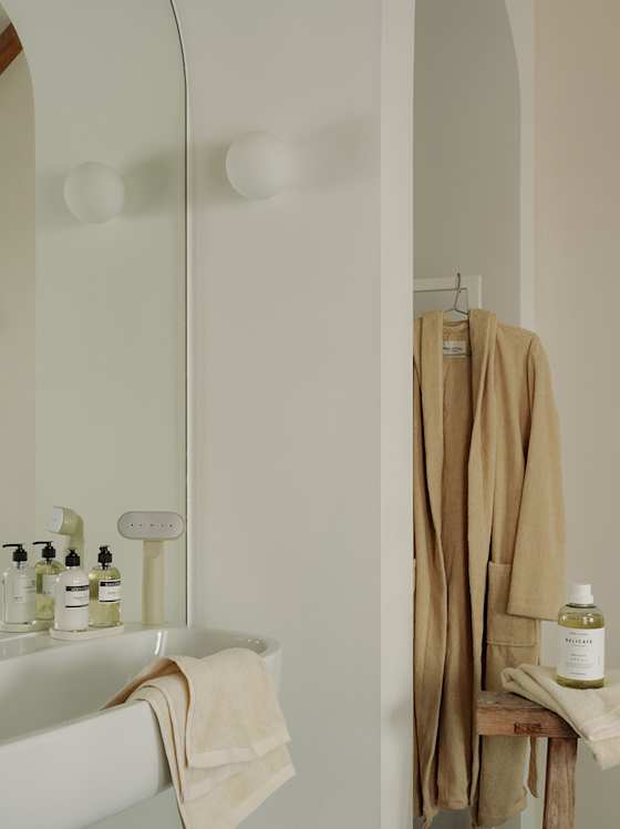 Minimalistisches Bad mit Badewanne, Handtüchern und Pflegeprodukten.